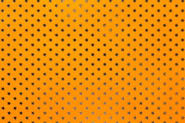 Altın yıldız desenli metal folyo kağıttan turuncu arka plan