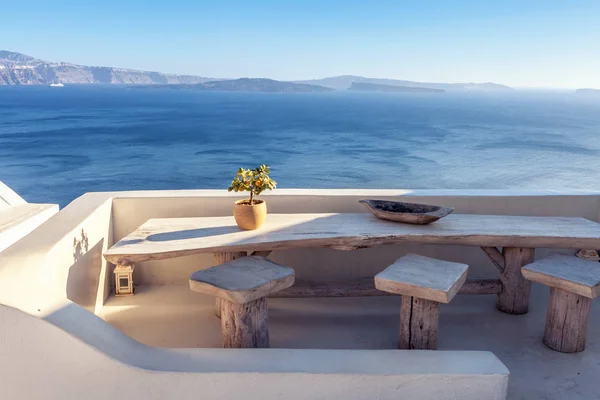 Casa exterior terraza con mesa vintage de madera con vistas al mar en Santorini, Grecia . — Foto de stock gratuita