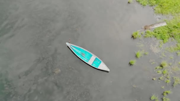 Altes blaues Holzboot schaukelt auf ruhigen Wellen. Ruhiger Morgen auf dem Fluss. Ansicht von oben — Stockvideo