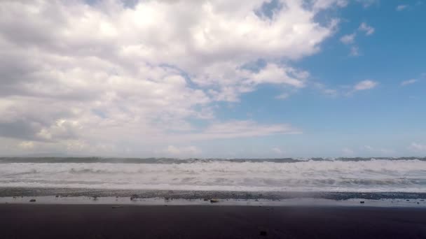 Grandes olas oceánicas rompiendo la orilla de la playa negra volcánica. Vista en cámara lenta. — Vídeos de Stock
