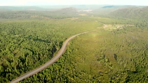 Panoramiczny widok z drona wsi wśród pól, lasów, rzek i wzgórz. Kręta droga i autostrada. — Wideo stockowe