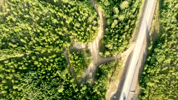 Légi istálló lövés egy vidéki út felett, kevés autóval az erdők között egy napsütéses napon.. — Stock videók