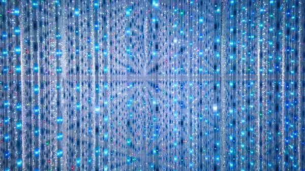 Blue and turquoise background of LED flashing, blinking and flickering bulbs. Disco and holiday illuminated neon shiny backdrop. Abstract wall decoration from twinkle garland for concert. Light Tunnel