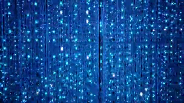 Blinkende Lichter weißer und blauer Farbe bewegen sich auf einem schwarzen Display. Künstlerischer Hintergrund — Stockvideo