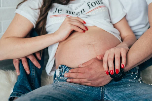 Hamile bir kadının karnı, elleri karnında, hamile bir kadının çıplak göbeği. — Stok fotoğraf