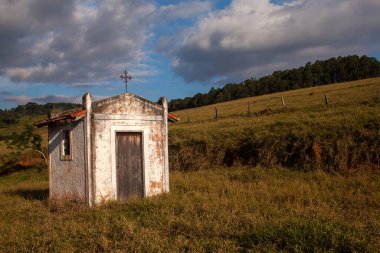 Kırsalda, mavi gökyüzünde küçük, eski beyaz bir kilise.