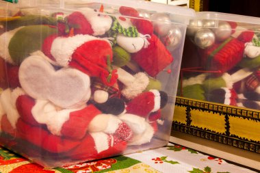 Şeffaf bir kutuda saklanmış Noel süsü. İçinde bir sürü Noel süsü olan plastik bir kutu.