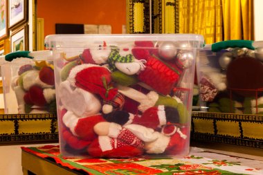 Şeffaf bir kutuda saklanmış Noel süsü. İçinde bir sürü Noel süsü olan plastik bir kutu.