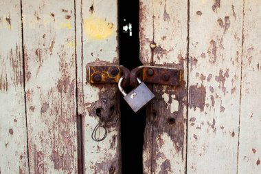 Paslı asma kilidi olan eski ahşap kapı.