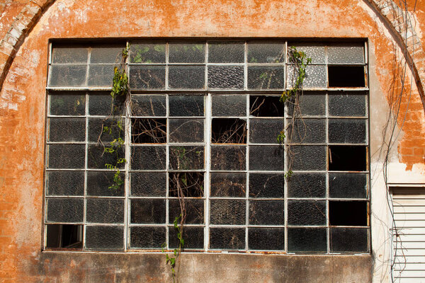 Old broken window glass on orange brick wall