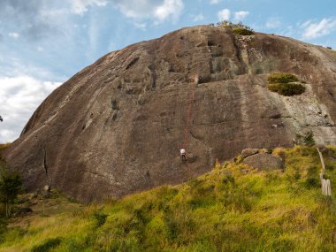 İnsanlar dik bir kayalık duvardan iniyor.