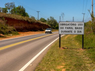 SAO PAULO, BRAZIL - 26 EYLÜL, 2016 - Yeni bir trafik levhası ile yol aydınlık bir araçla gün boyunca bile farların açık kalmasını gerektiren yeni bir yasa