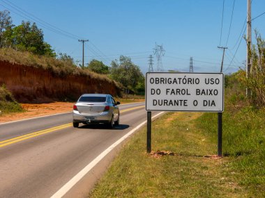 SAO PAULO, BRAZIL - 26 EYLÜL, 2016 - Yeni bir trafik levhası ile yol aydınlık bir araçla gün boyunca bile farların açık kalmasını gerektiren yeni bir yasa