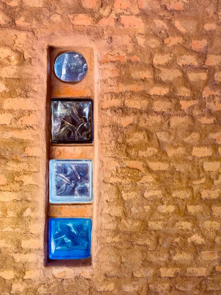 Brick wall with colored glass brick as windows in a rustic house