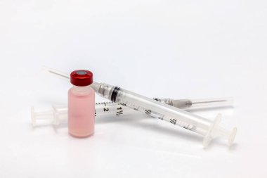 Renkli sıvıyla izole edilmiş plastik aşı şişesi ve boş iki şırınga.