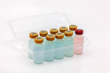 İçindeki on aşı şişesi şeffaf plastik kutuyu farklı bir şişeyle açtı.