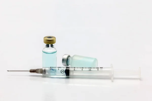 装有彩色液体和彩色液体注射器的隔离玻璃瓶和塑料疫苗瓶 — 图库照片