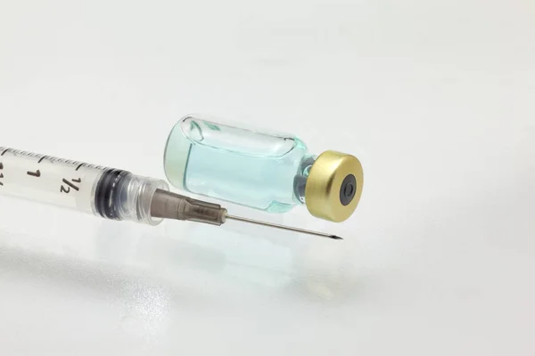 装有彩色液体和注射器的分离玻璃疫苗瓶非常接近高倍放大模型 — 图库照片