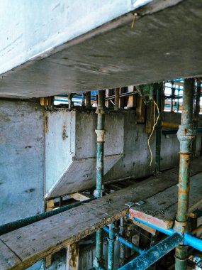 İnşaat iskelesi ve bir sürü mavi ve yeşil metali olan bir şantiye. Manzara endüstriyel ve muhtemelen kaotik.