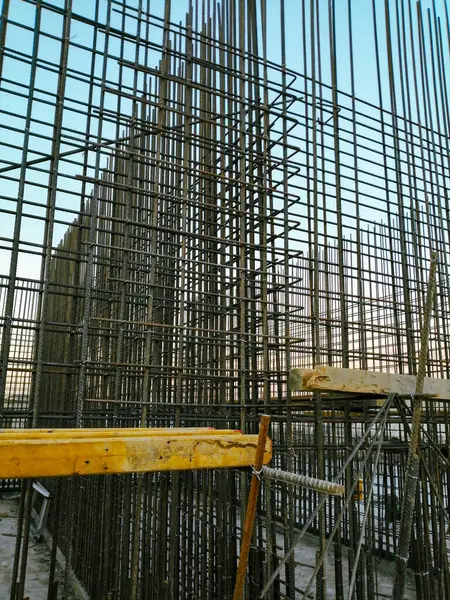 A construction site with scaffolding and a large metal structure. Scene is one of hard work and progress