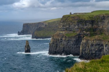 İrlanda'da deniz üzerinde çimenli kayalıkların Manzarası