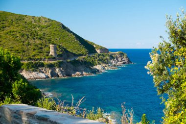Korsika tatil beldesinde kıyı manzarası ve antik kale kulesi, Fransa