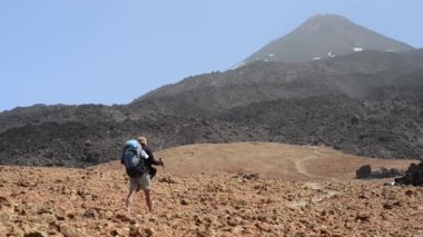 Turist volkanlar Teide ve Pico Viejo arka gidiyor. Uzun yürüyüşe çıkan kimse adam güzel dağ doğa manzara içinde. Kanarya Adaları, İspanya