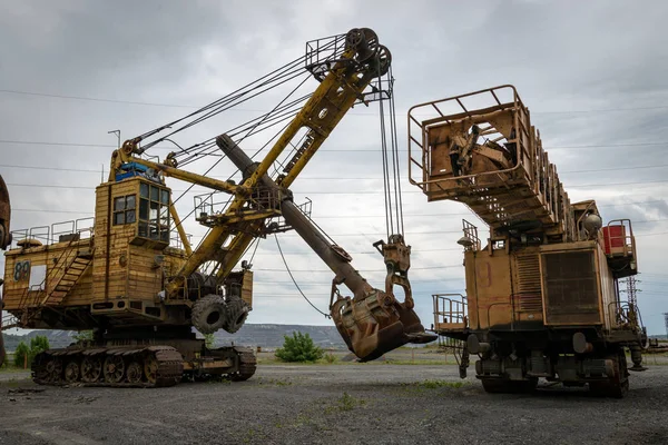 stock image Giant excavators are on the brink of a great career. This is an old rusty technology that has served its resources.