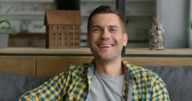 Gülümseyen genç adam Tv izliyor