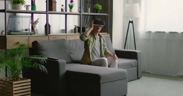 Man draagt Virtual Reality headset in woonkamer — Stockvideo