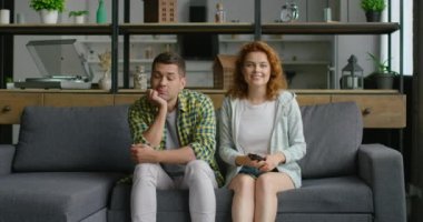 Adam ve kadın oturma odasında TV pipo vardır