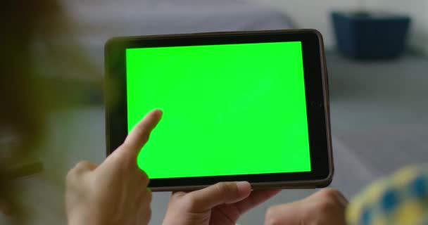 Kvinna och man använda en Tablet PC med en grön skärm för att göra ett köp — Stockvideo