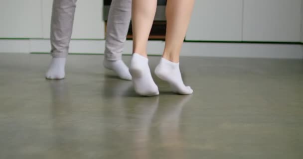 キッチンで踊る若い女性と男の足を閉じる — ストック動画