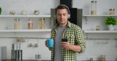 Kablosuz kulaklıkta genç adam evde dans ediyor