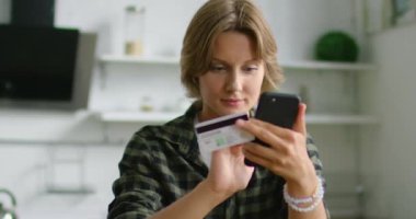 Genç kadın mutfakta online alışveriş yapıyor