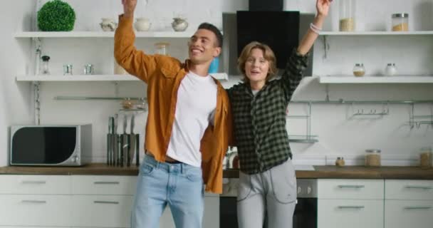 Glücklich lateinischen Mann und weiße Frau tanzen in ihrer neuen Küche — Stockvideo