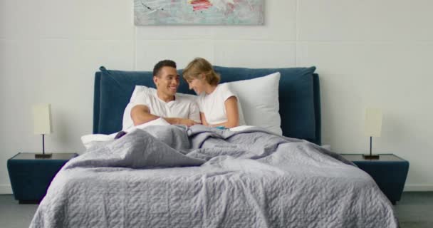 Молодая пара, лежащая утром в постели — стоковое видео