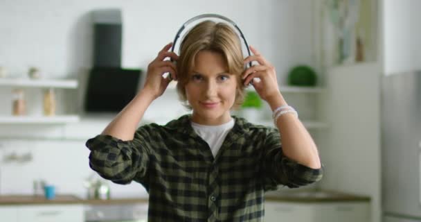 Retrato de jovem mulher colocando fone de ouvido sem fio — Vídeo de Stock