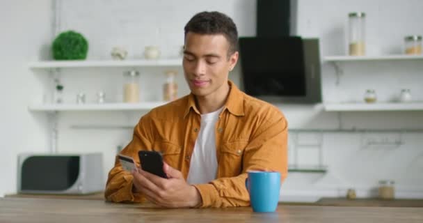Młody Hiszpan jest wpisanie numeru karty kredytowej w swoim smartfonie, gadżet — Wideo stockowe