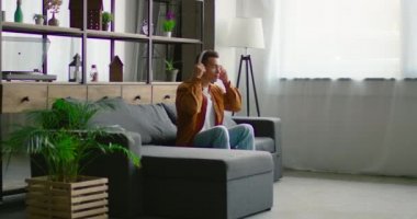 Genç İspanyol adam müzik dinleyerek eğlenmek, kablosuz kulaklık koyarak