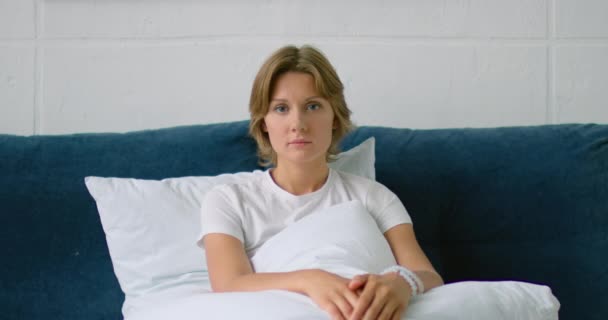 Портрет молодой женщины, лежащей в постели утром — стоковое видео