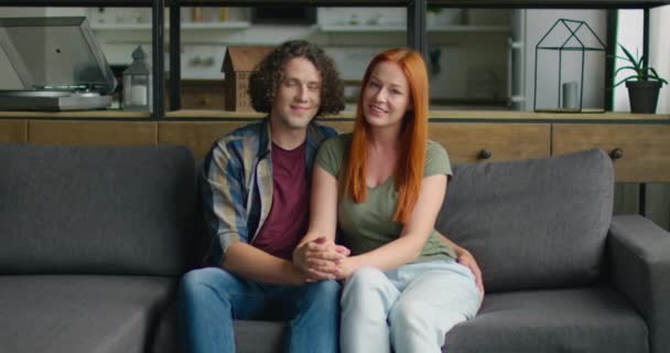 Portrait of young couple in love, sitting on sofa at home — Stock Video