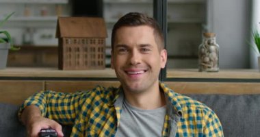 Genç adam tv izlemekten, komik programa, filme, yakın çekime gülmekten hoşlanıyor.