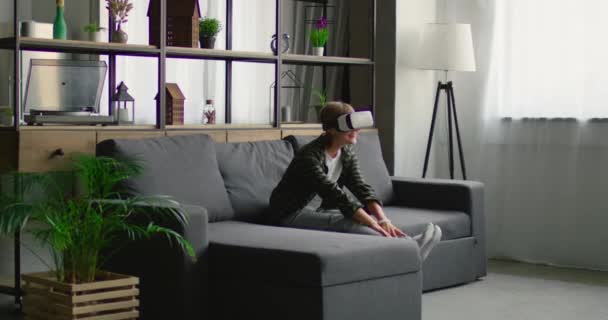 Wanita menikmati mengenakan headset realitas virtual, menggunakan gerak tubuh untuk menyentuh gambar — Stok Video