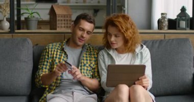 Erkek ve kadın, tablet bilgisayar ve kredi kartı kullanarak, online alışveriş yapmak