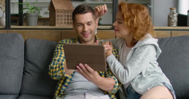 Man en vrouw hebben een video-chat op Tablet PC, zittend op de Bank — Stockvideo