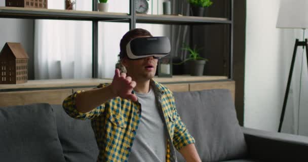 Man är imponerad av virtuell verklighet, bär VR-headset hemma — Stockvideo
