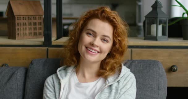 Portrait of young cheerful woman, sitting on sofa, close up — Stock Video