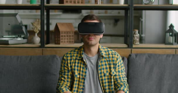 Чоловік розслабляється в гарнітурі віртуальної реальності вдома — стокове відео