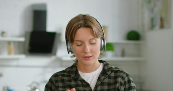 Mujer en el estado de ánimo romántico está escuchando música en auriculares inalámbricos, de cerca — Vídeos de Stock